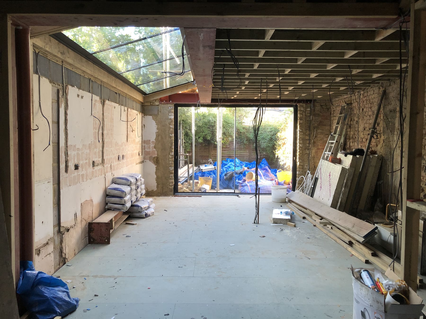 Extension interior with structural steels, glazed roof and sliding doors to the garden