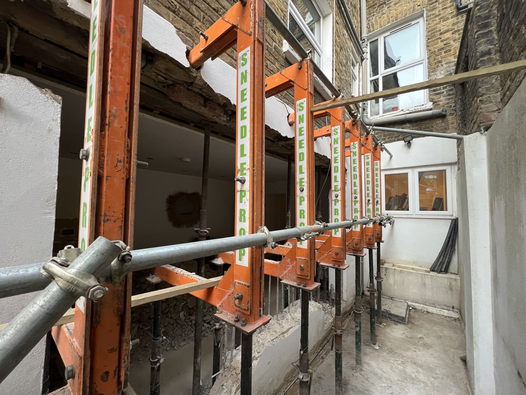 Needle props and scaffolding supporting the rear facade of a Fulham terrace during structural works