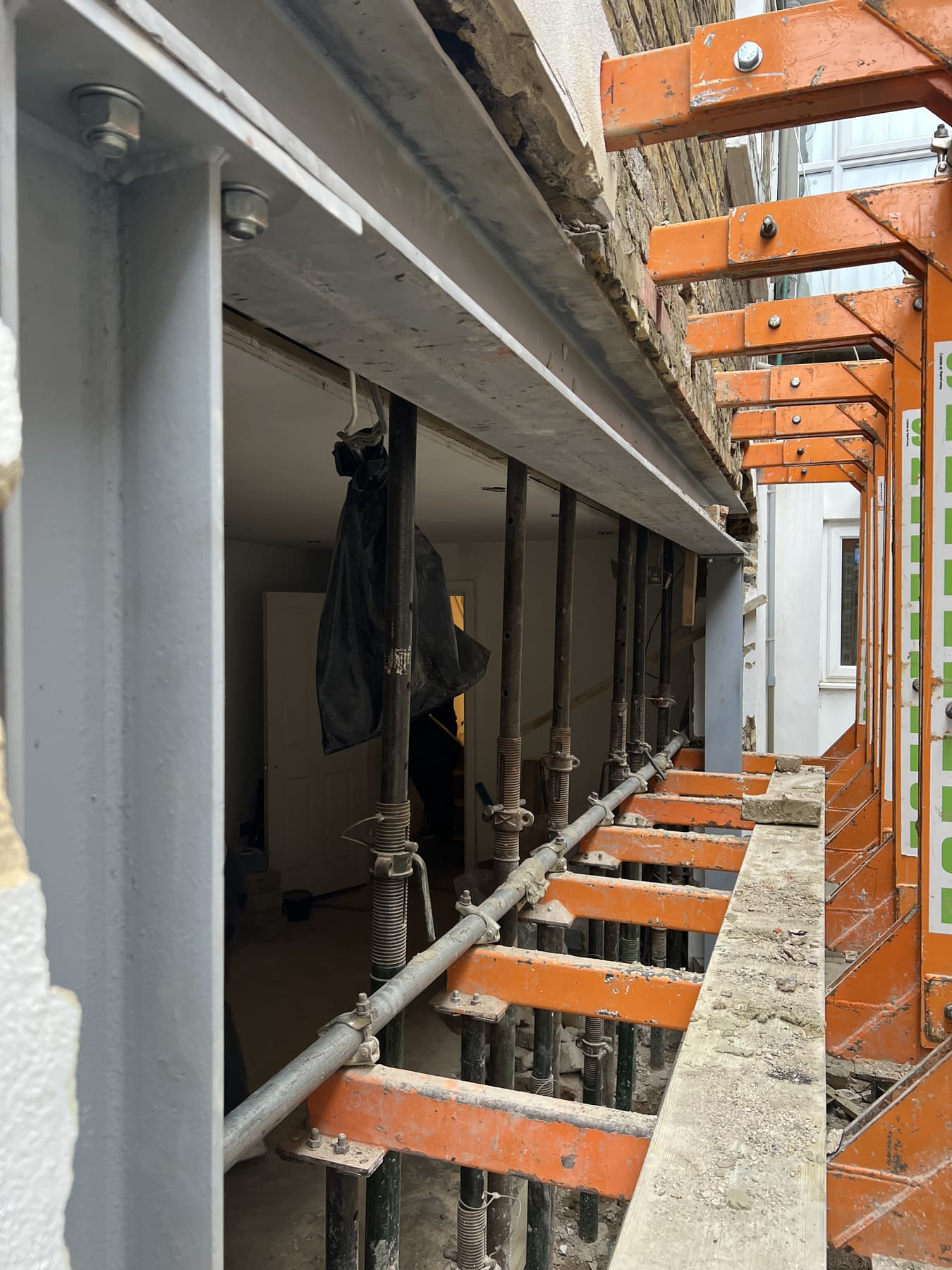 New steel beam installed on needle props during structural alterations